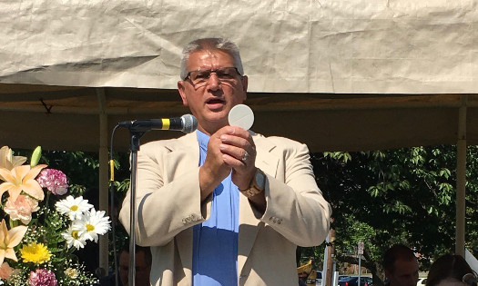 pastor jim hold a communion wafer at the annual outdoor service